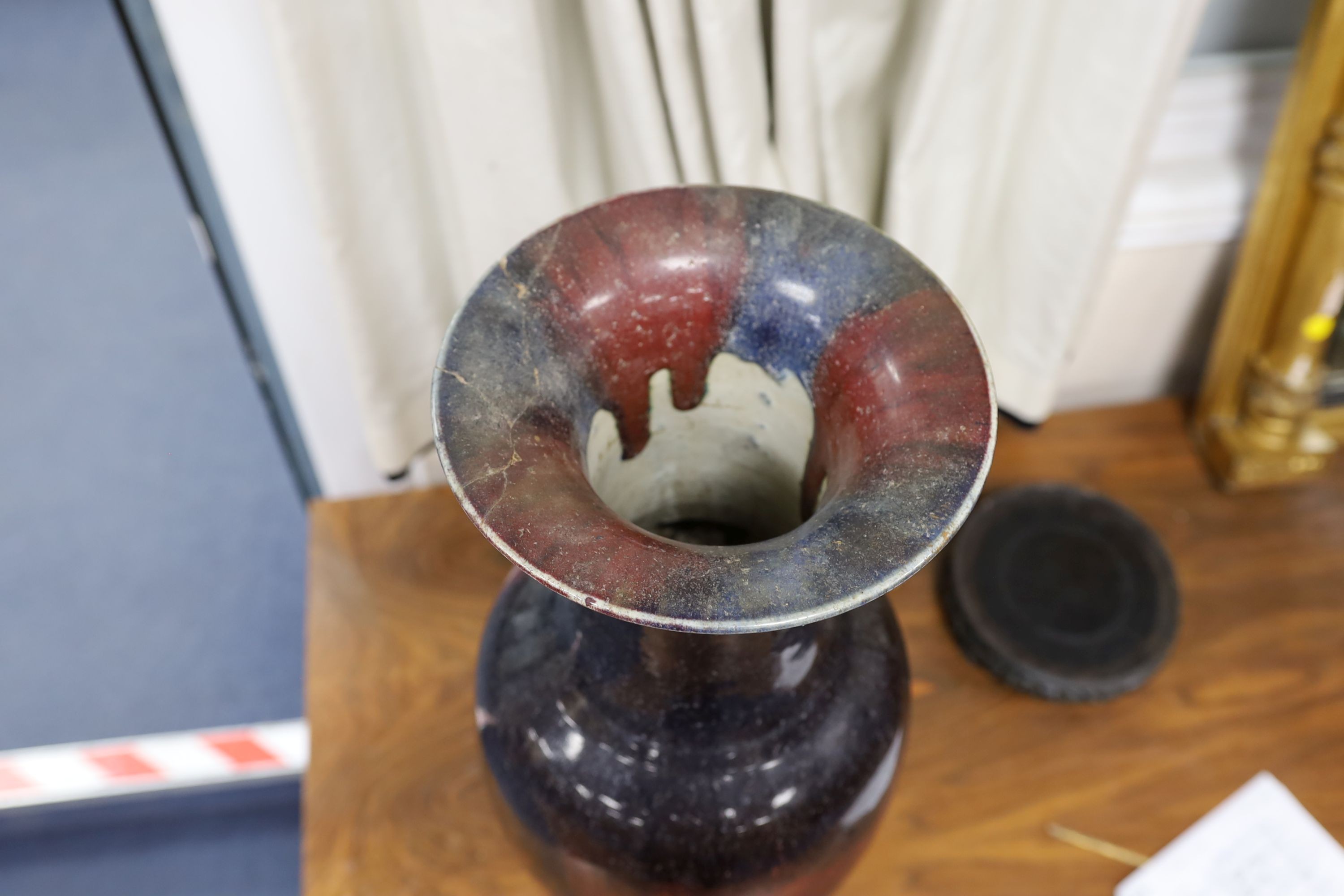 A large Chinese sang de boeuf glazed vase on carved wooden stand., Vase 61 cms high not including stand.